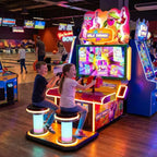 Two children playing Wild Things at a bowling alley in the evening